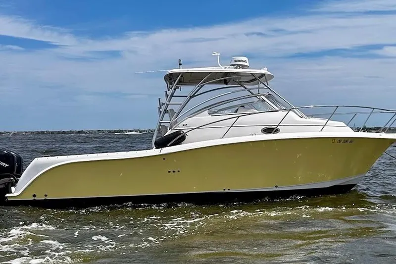 Slide: The Image of 2006 Pro-Line 32 Express boat on water, yellow hull, clear sky background. - 3