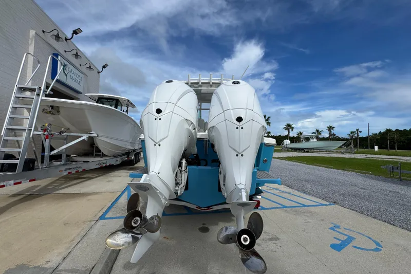 Slide: The Image of 2023 Albemarle 27 Dual Console boat with twin outboard engines at a marina. - 13