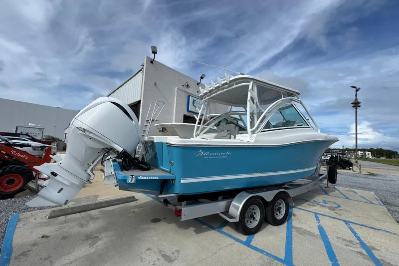 Slide: The Image of 2023 Albemarle 27 Dual Console boat on trailer, blue and white design, parked outdoors. - 15
