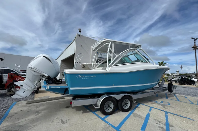 Slide: The Image of 2023 Albemarle 27 Dual Console boat on trailer, blue hull, parked outdoors. - 16