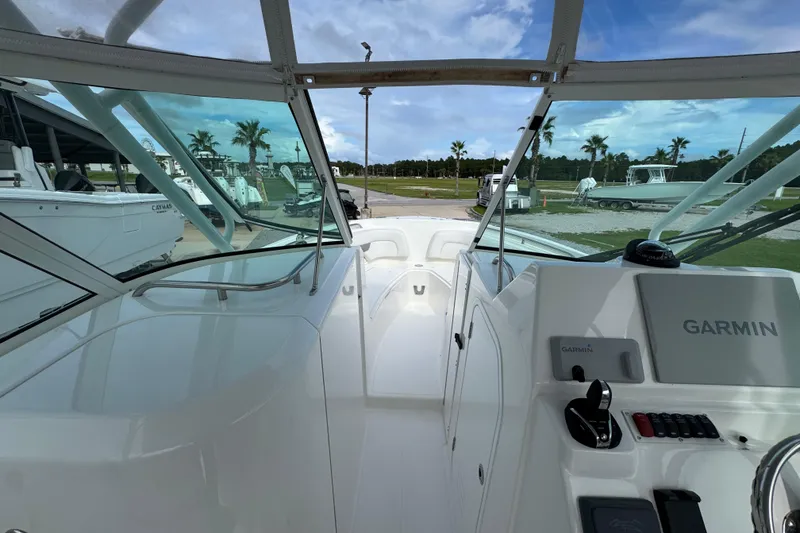 Slide: The Image of 2023 Albemarle 27 Dual Console boat interior with Garmin navigation system, docked near palm trees. - 21