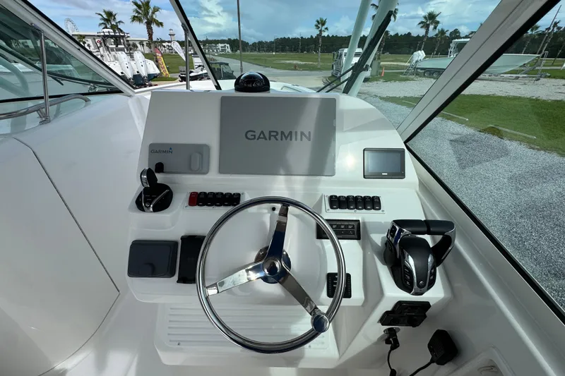 Slide: The Image of 2023 Albemarle 27 Dual Console boat dashboard with Garmin navigation system and steering wheel. - 23
