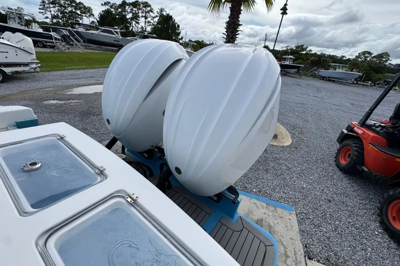 Slide: The Image of 2023 Albemarle 27 Dual Console with twin outboard engines in a boatyard setting. - 37