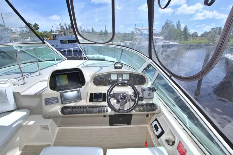 Slide: The Image of 2004 Cruisers Yachts 370 Express helm with navigation equipment and scenic marina view. - 17