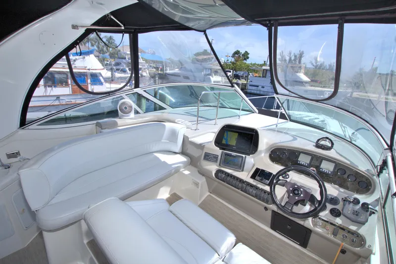 Slide: The Image of 2004 Cruisers Yachts 370 Express cockpit with white seating and modern navigation controls. - 19