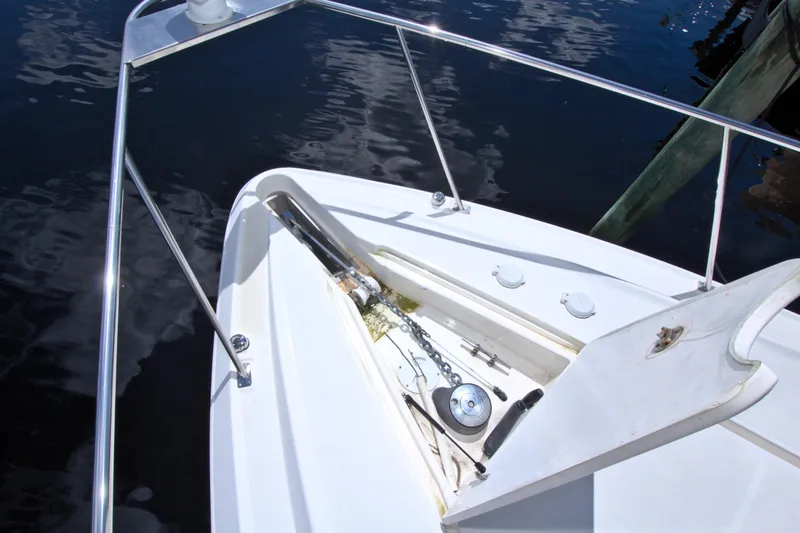 Slide: The Image of 2004 Cruisers Yachts 370 Express bow with anchor and railing, docked on calm water. - 23