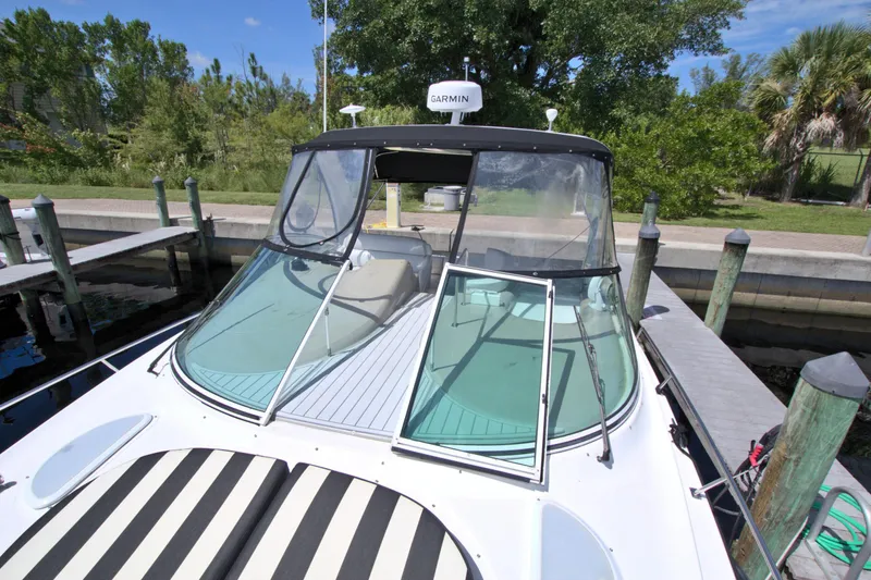 Slide: The Image of 2004 Cruisers Yachts 370 Express docked, featuring a sleek windshield and striped sunpad. - 26
