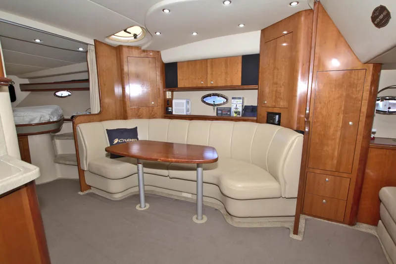 Slide: The Image of 2004 Cruisers Yachts 370 Express interior with beige seating and wooden cabinetry. - 31