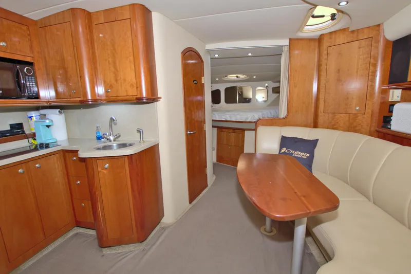 Slide: The Image of 2004 Cruisers Yachts 370 Express interior with kitchenette, seating, and sleeping area. - 36