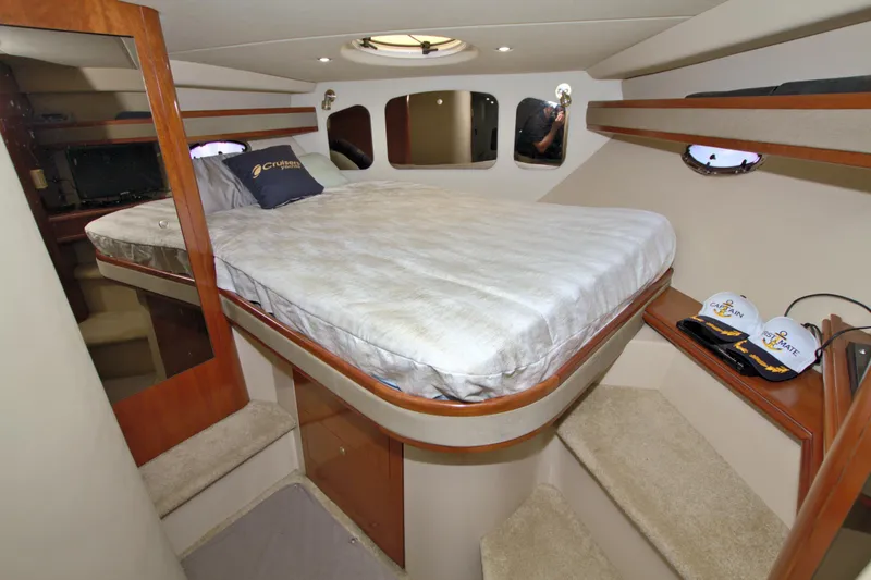 Slide: The Image of 2004 Cruisers Yachts 370 Express cabin interior with bed and storage shelves. - 37