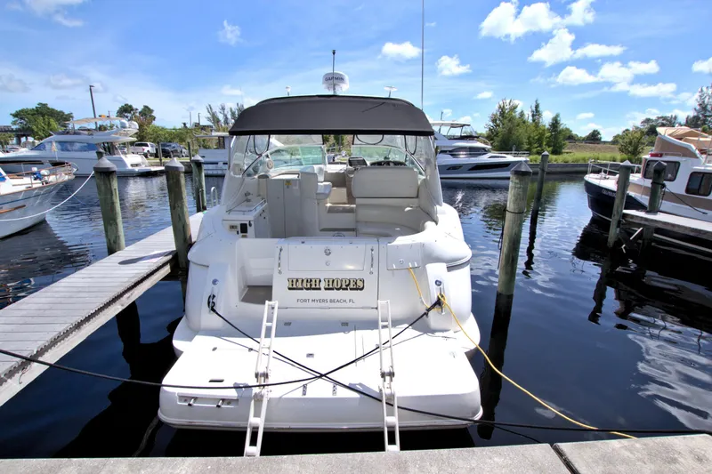 Slide: The Image of 2004 Cruisers Yachts 370 Express docked at marina under clear blue sky. - 4