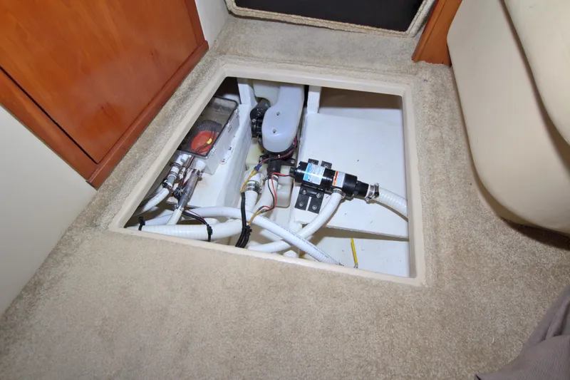Slide: The Image of 2004 Cruisers Yachts 370 Express interior compartment with wiring and plumbing. - 43