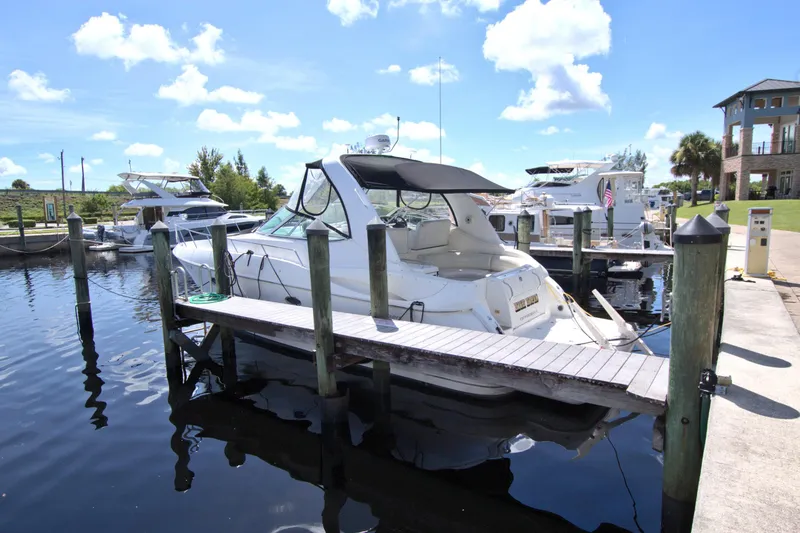 Slide: The Image of 2004 Cruisers Yachts 370 Express docked at a marina under a clear blue sky. - 5