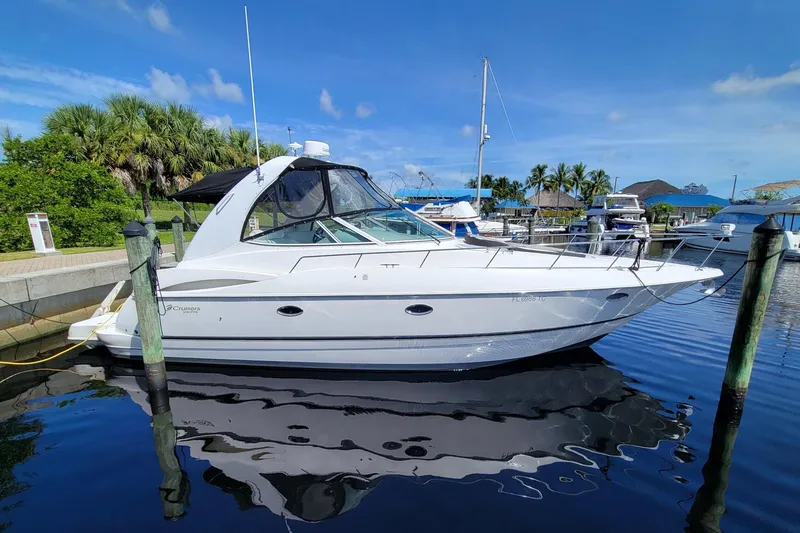 The Image of 2004 Cruisers Yachts 370 Express docked in a marina under clear blue skies. - 0