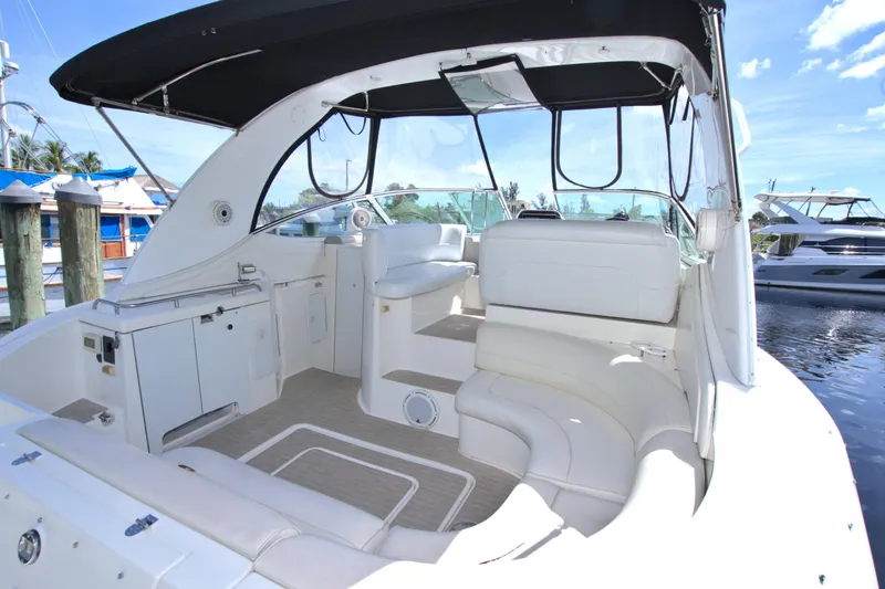 Slide: The Image of 2004 Cruisers Yachts 370 Express with white seating and canopy, docked by the water. - 12