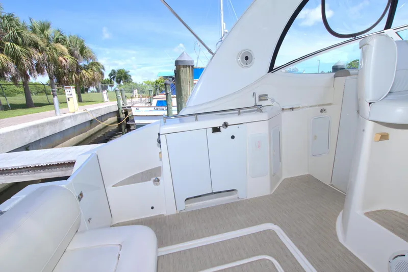 Slide: The Image of 2004 Cruisers Yachts 370 Express interior with seating and dockside view. - 13