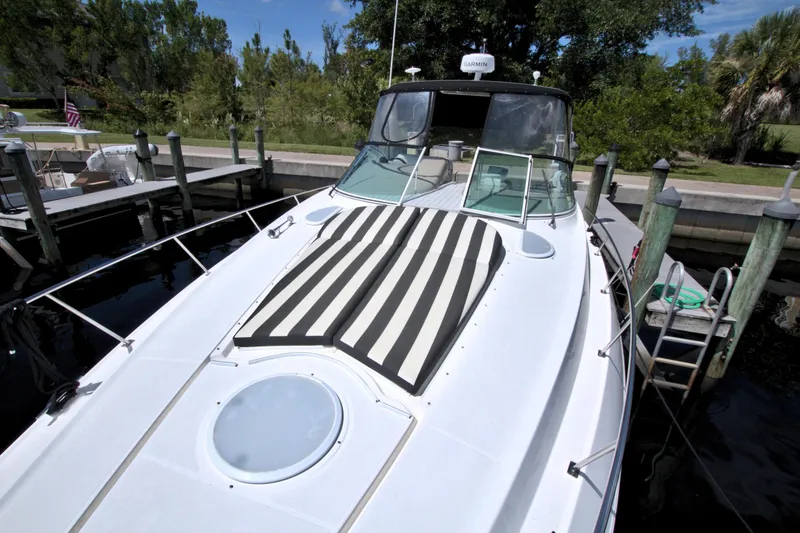 Slide: The Image of 2004 Cruisers Yachts 370 Express docked, featuring striped sun pad and sleek design. - 24