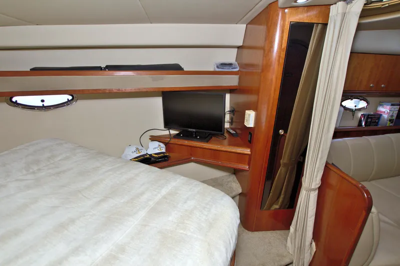 Slide: The Image of 2004 Cruisers Yachts 370 Express cabin interior with bed, TV, and wooden furnishings. - 38