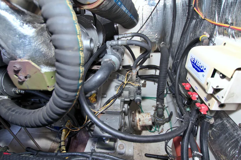 Slide: The Image of Engine compartment of 2004 Cruisers Yachts 370 Express, featuring hoses and mechanical components. - 57
