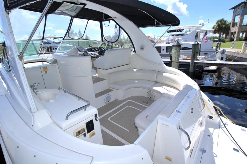 Slide: The Image of 2004 Cruisers Yachts 370 Express, spacious cockpit with seating, docked at marina. - 9