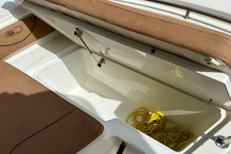 Slide: The Image of 2015 Sea Hunt Ultra 234 boat storage compartment with yellow rope inside. - 14