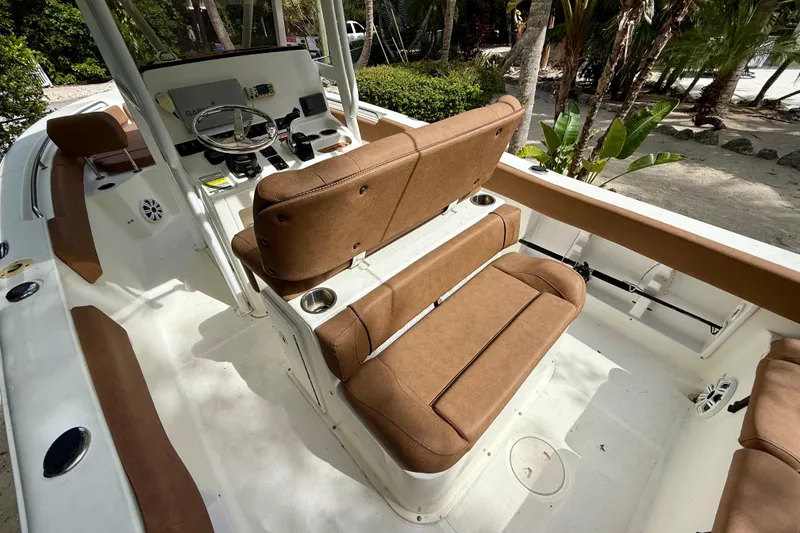 Slide: The Image of 2015 Sea Hunt Ultra 234 boat interior with brown seating and steering console. - 21