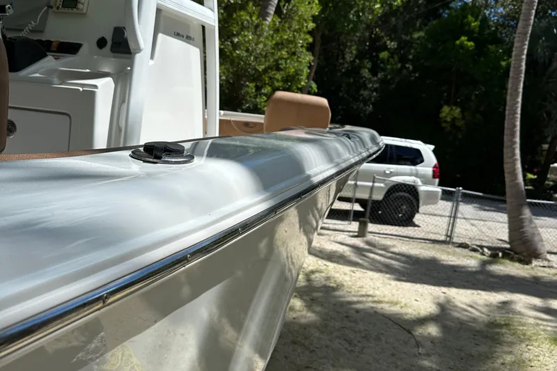 Slide: The Image of 2015 Sea Hunt Ultra 234 boat side view with a parked SUV in the background. - 29