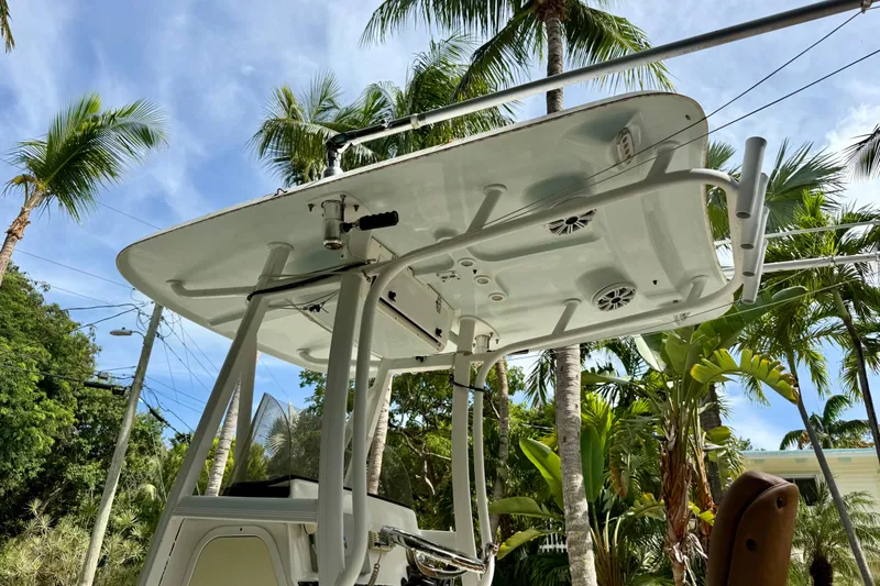 Slide: The Image of 2015 Sea Hunt Ultra 234 boat with T-top, surrounded by palm trees. - 3