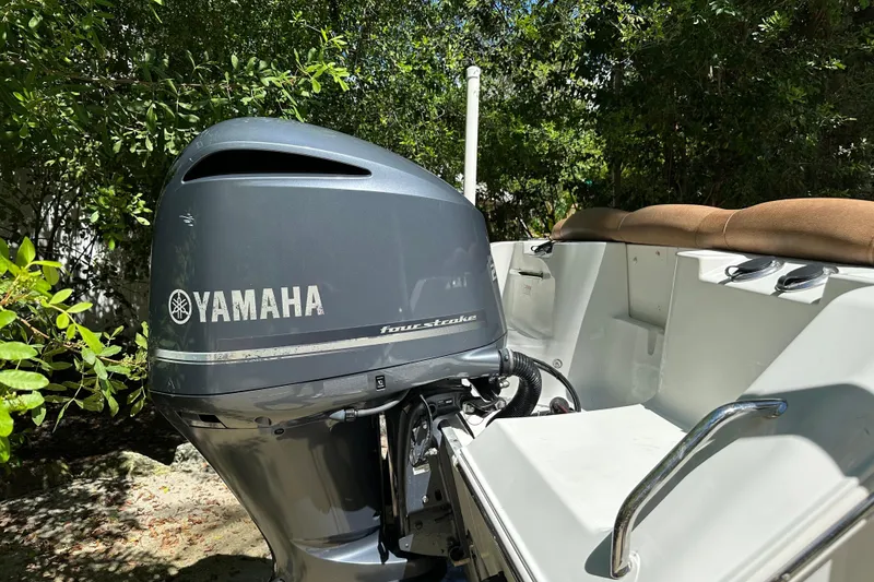 Slide: The Image of 2015 Sea Hunt Ultra 234 boat with Yamaha four-stroke outboard motor, surrounded by greenery. - 37