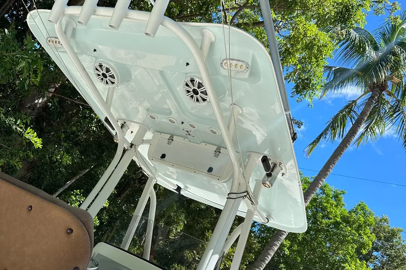 Slide: The Image of 2015 Sea Hunt Ultra 234 boat canopy with speakers, surrounded by palm trees and blue sky. - 39