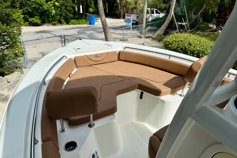 Slide: The Image of 2015 Sea Hunt Ultra 234 boat with brown cushioned seating in a tropical setting. - 4