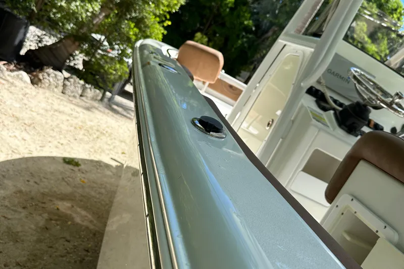 Slide: The Image of 2015 Sea Hunt Ultra 234 boat interior with steering wheel and seating, surrounded by greenery. - 41