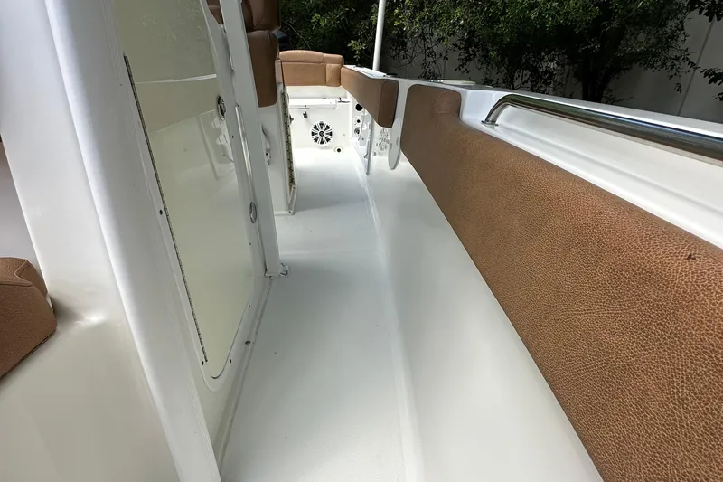 Slide: The Image of 2015 Sea Hunt Ultra 234 boat interior with brown cushioned seating and white flooring. - 45