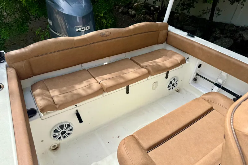 Slide: The Image of 2015 Sea Hunt Ultra 234 boat interior with tan cushioned seating and Yamaha 250 engine. - 6