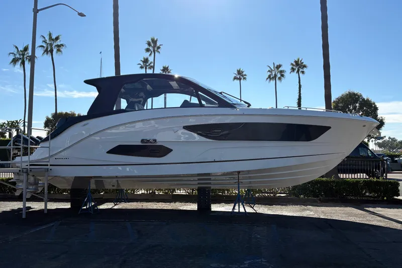 The Image of 2026 Sea Ray Sundancer 370 Outboard boat displayed outdoors with palm trees in the background. - 0