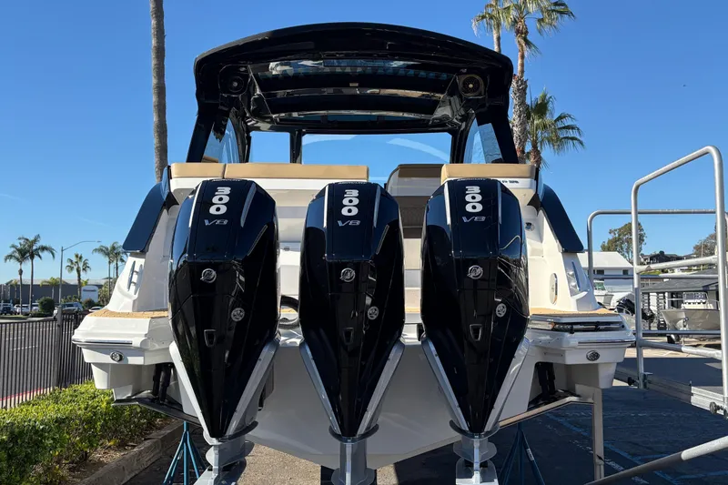 Slide: The Image of 2026 Sea Ray Sundancer 370 Outboard with triple 300 V8 engines, docked under clear skies. - 5