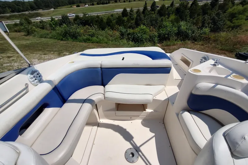Slide: The Image of 2005 Rinker 232 Captiva Cuddy boat interior with blue and white seating. - 14
