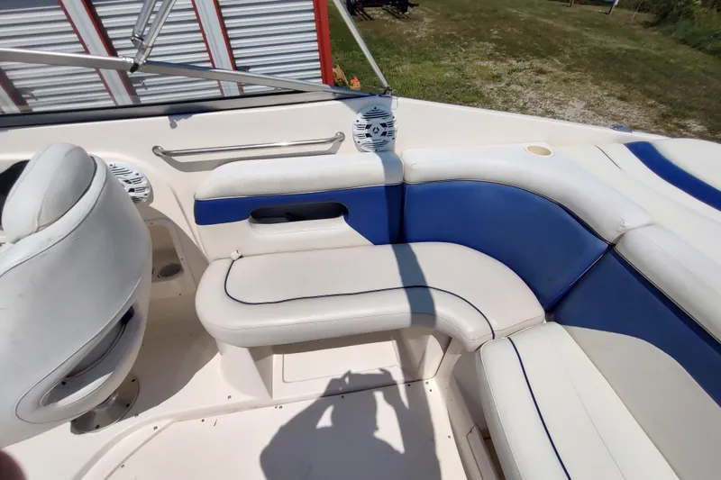 Slide: The Image of 2005 Rinker 232 Captiva Cuddy boat interior with blue and white seating. - 15