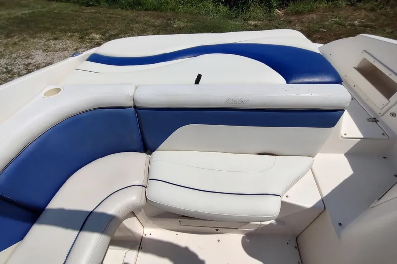 Slide: The Image of 2005 Rinker 232 Captiva Cuddy boat interior with blue and white seating. - 16