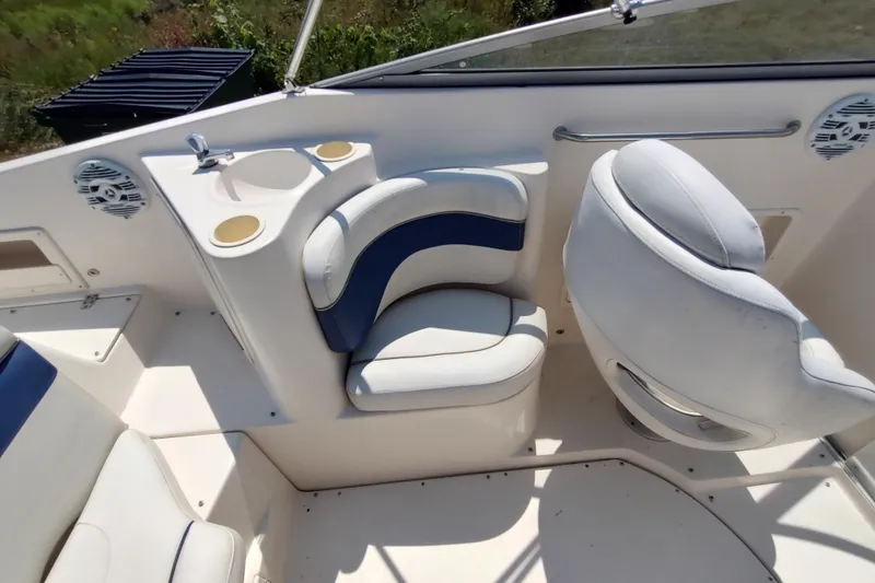 Slide: The Image of 2005 Rinker 232 Captiva Cuddy boat interior with white and blue seating. - 17