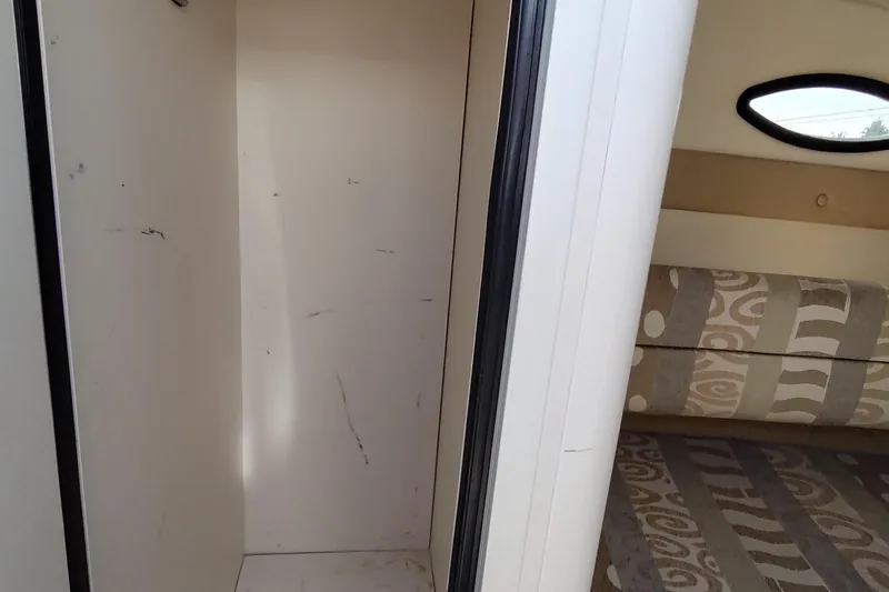 Slide: The Image of 2005 Rinker 232 Captiva Cuddy interior with patterned seating and storage space. - 20