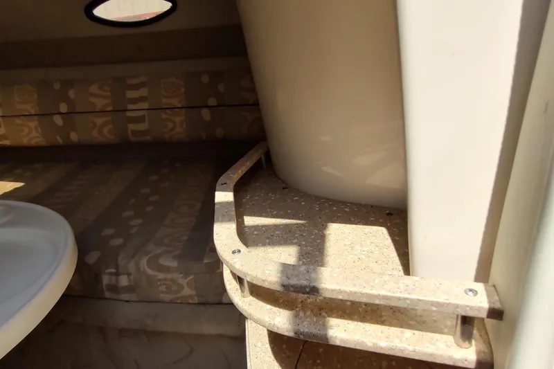 Slide: The Image of 2005 Rinker 232 Captiva Cuddy interior with patterned cushions and compact design. - 21