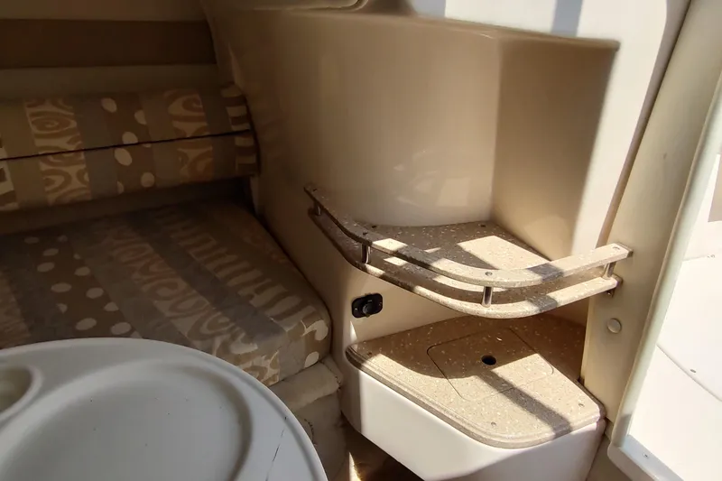 Slide: The Image of 2005 Rinker 232 Captiva Cuddy interior with patterned seating and compact storage. - 22