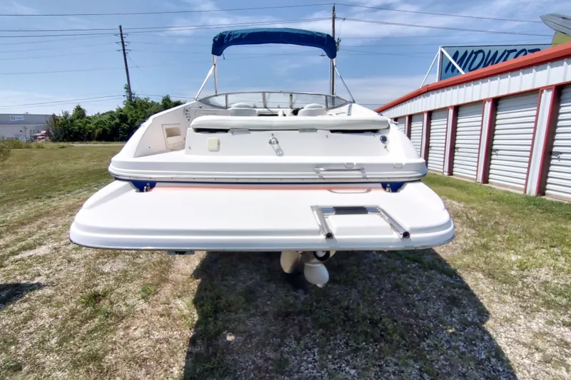 Slide: The Image of 2005 Rinker 232 Captiva Cuddy boat with swim platform, parked outdoors. - 26
