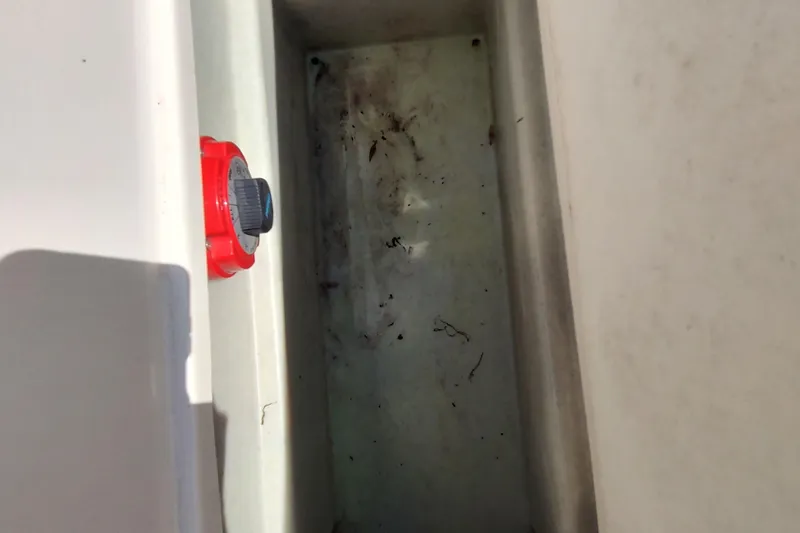 Slide: The Image of 2005 Rinker 232 Captiva Cuddy boat compartment with red control knob. - 4