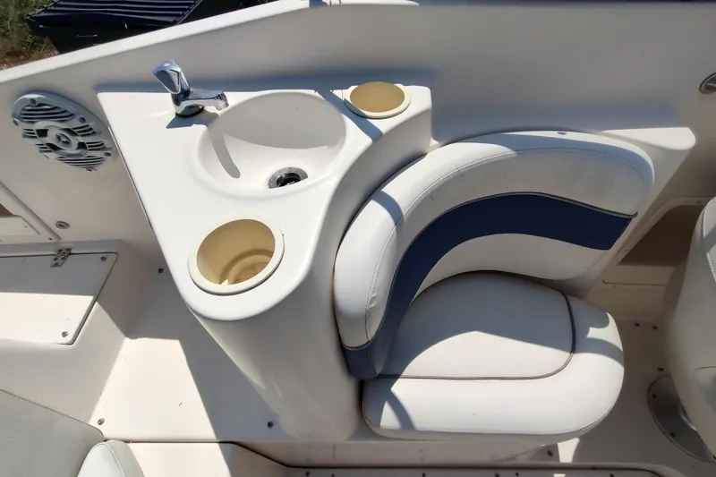 Slide: The Image of 2005 Rinker 232 Captiva Cuddy interior with sink, cup holders, and cushioned seating. - 7