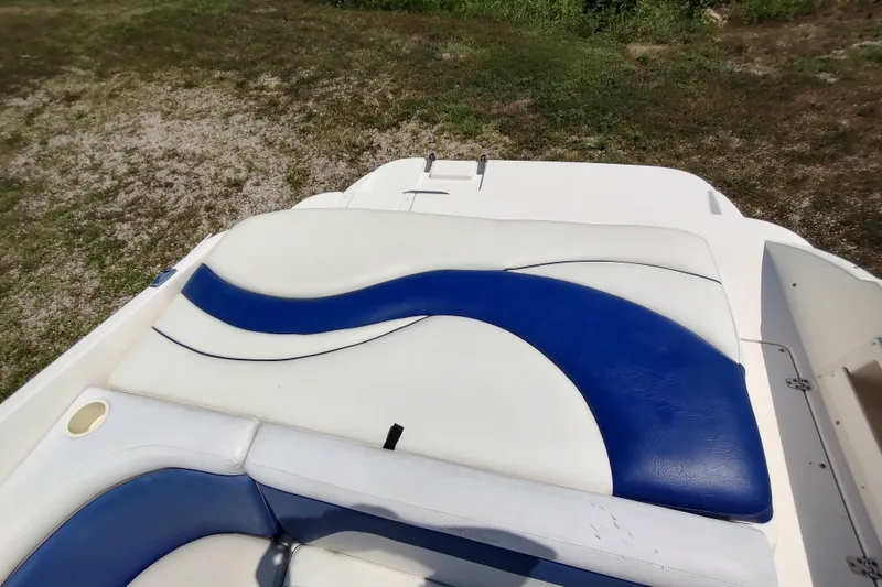 Slide: The Image of 2005 Rinker 232 Captiva Cuddy boat with blue and white seating design. - 9
