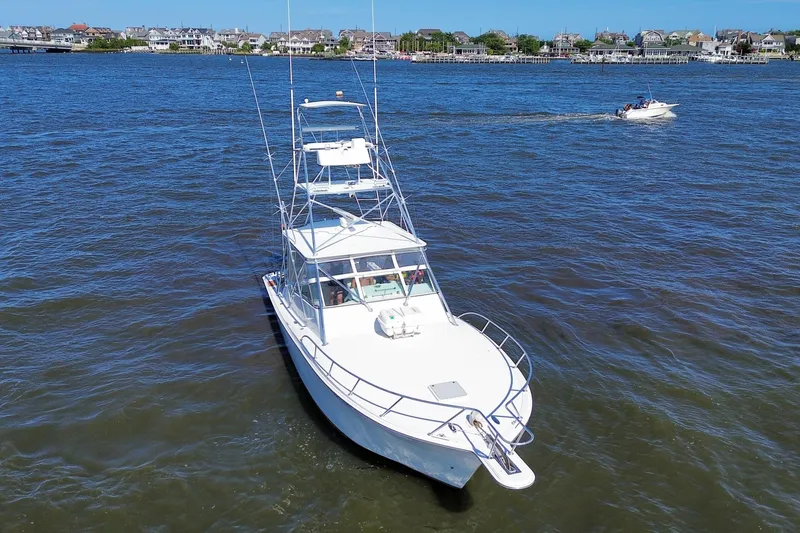 Slide: The Image of 2006 Topaz 40 Express boat on blue water near coastal town. - 10