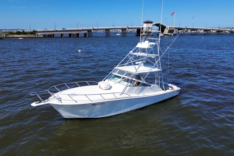 Slide: The Image of 2006 Topaz 40 Express boat on water near a bridge under clear blue sky. - 11