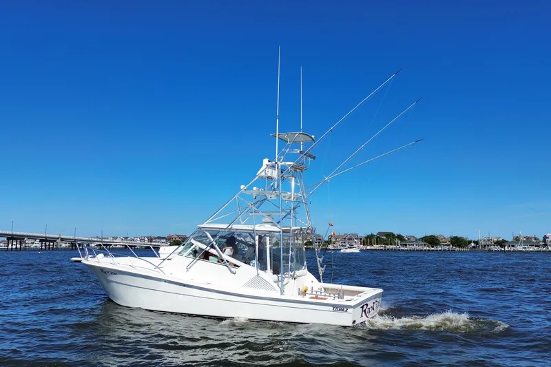Slide: The Image of 2006 Topaz 40 Express boat cruising on a sunny day with clear blue skies. - 13